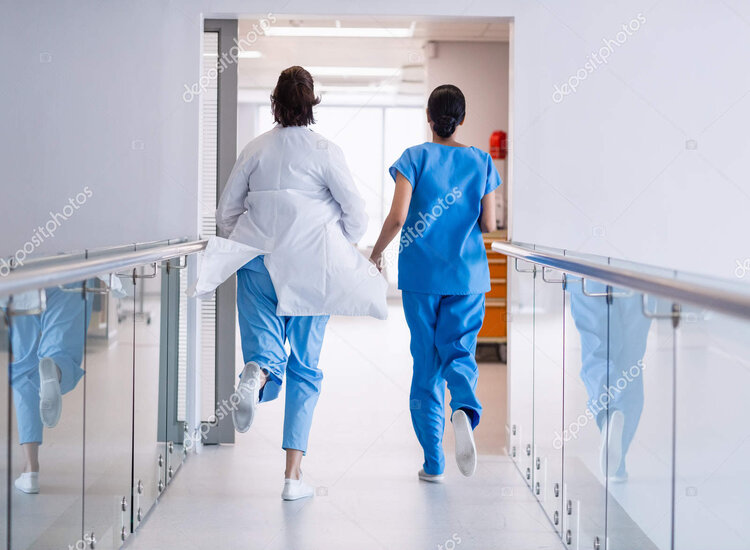 Rear view of nurse and doctor running in hospital corridor